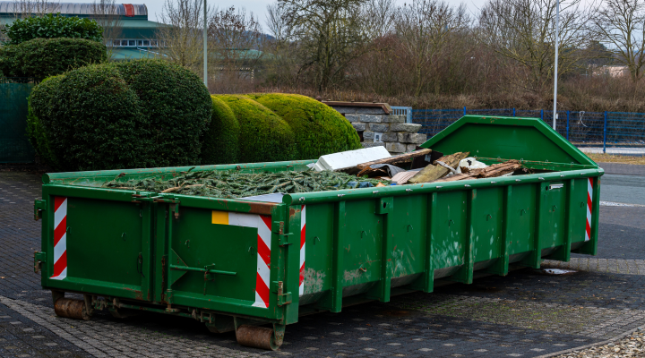 10-yard dumpster rental parked in a residential driveway, filled with heavy construction debris.