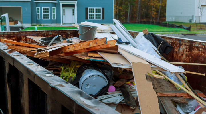 Dumpster for home renovation filled with debris.